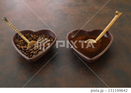 Roasted coffee beans in heart shaped bowl on dark background. Love coffee concept. Top view flat lay 131199642