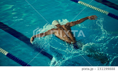 Competitive swimmer performing butterfly stroke with strong form 131199888