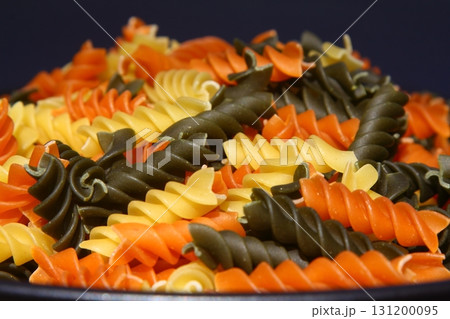 Colorful various raw fusilli on black plate Colorful various raw fusilli on black plate 131200095