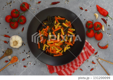 Colorful various raw fusilli on black plate Colorful various raw fusilli on black plate 131200099