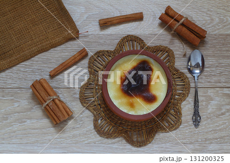 Baked rice pudding turkish dessert sutlac in earthenware casserole with cinnamon sticks 131200325