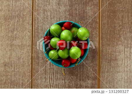 Single whole fresh green Can Erik plum and cherry close up isolated on dark background 131200327
