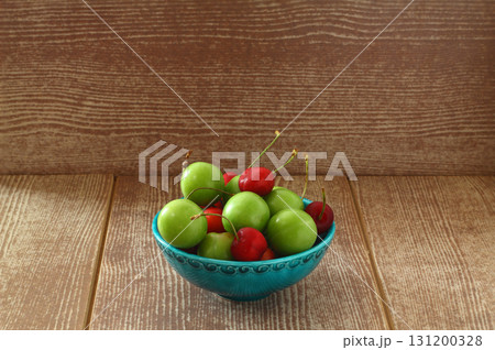 Single whole fresh green Can Erik plum and cherry close up isolated on dark background 131200328