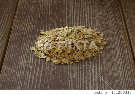 Oat flake in a sack and spoon on the wooden table Oat flake in a sack and spoon on the wooden table 131200330