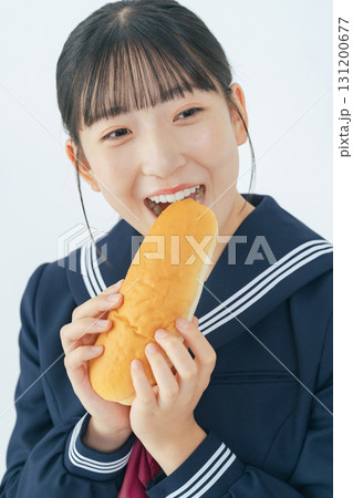 コッペパンを食べるセーラー服を着た女子学生 131200677