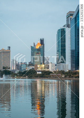 evening panorama of Bangkok city skyline with skyscrapers and Benchakitti park lake, vibrant cityscape view with reflections over pond water at dusk evening panorama of Bangkok city skyline with skyscrapers and Benchakitti park lake, vibrant cityscape view with reflections over pond water at dusk 131201366