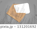 Natural lighting casts shadows from the field grass on an envelope with a sheet of white paper lying on a gray background. Mockup 131201692