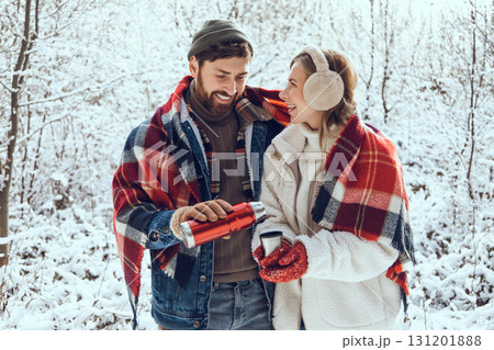 Smiling man pouring hot tea to his girl friend cup and both looking enjoyed 131201888