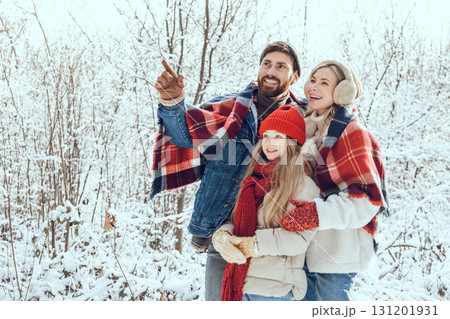 Happy and enjoyed young family spending time in a winter forest 131201931