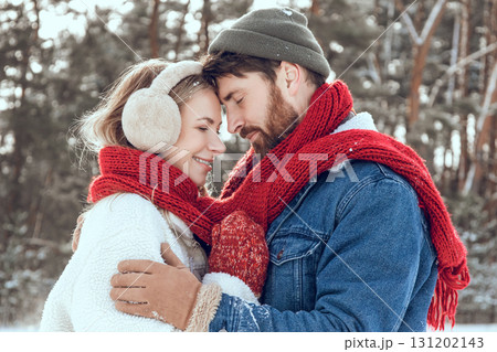 Man and woman looking romantic while having a walk in a winter forest Man and woman looking romantic while having a walk in a winter forest 131202143