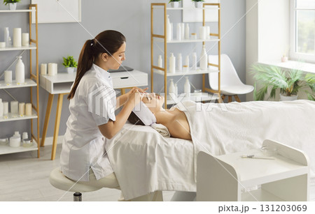 Cosmetologist making anti-age procedures to woman in beauty clinic. Skin care concept. Cosmetologist making anti-age procedures to woman in beauty clinic. Skin care concept. 131203069