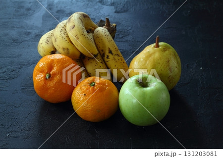 a lot of ripe and juicy fruit on a black background. Apples, pears, banana and Mandarin together. a lot of ripe and juicy fruit on a black background. Apples, pears, banana and Mandarin together. 131203081