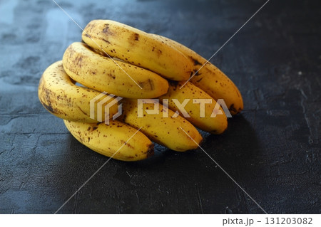 Ripe banana with black patches on the skin. Old banana isolated on black background Ripe banana with black patches on the skin. Old banana isolated on black background 131203082