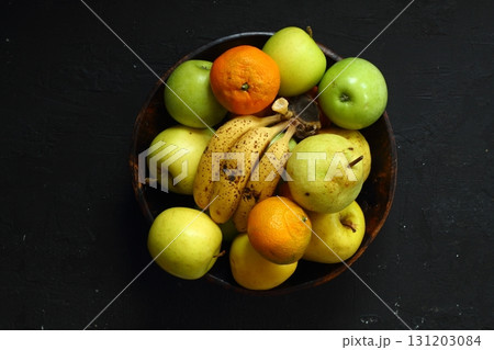 a lot of ripe and juicy fruit on a black background. Apples, pears, banana and Mandarin together. a lot of ripe and juicy fruit on a black background. Apples, pears, banana and Mandarin together. 131203084