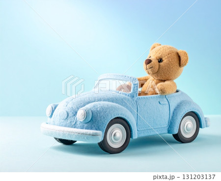 青いフェルトの車に乗った可愛いくまのぬいぐるみ　やさしい背景のシンプルで温かい構図 131203137