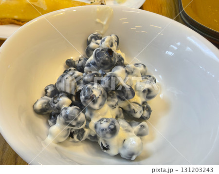 Fresh blueberries drenched in creamy yogurt create a delightful treat 131203243