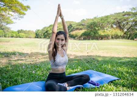 A woman practicing yoga outdoors, surrounded by nature and greenery. A woman practicing yoga outdoors, surrounded by nature and greenery. 131204634