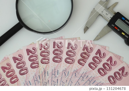 Turksh Lira banknotes of various color, pattern and value on white background. with caliper and magnifying glass 131204678