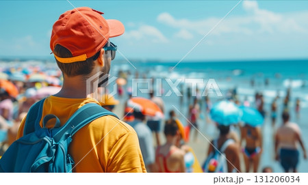 A young man enjoys a vibrant beach scene, surrounded by colorful umbrellas and lively crowds under a sunny sky. 131206034
