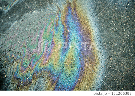 Gasoline or oil spill creating rainbow sheen on asphalt road surface Gasoline or oil spill creating rainbow sheen on asphalt road surface 131206395