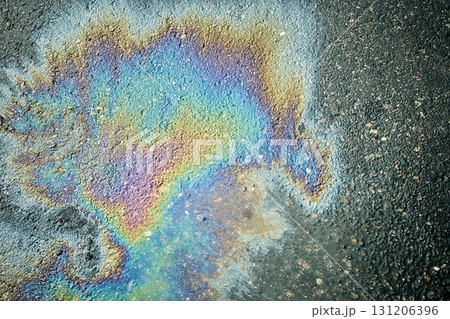 Gasoline or oil spill creating rainbow sheen on asphalt road surface Gasoline or oil spill creating rainbow sheen on asphalt road surface 131206396