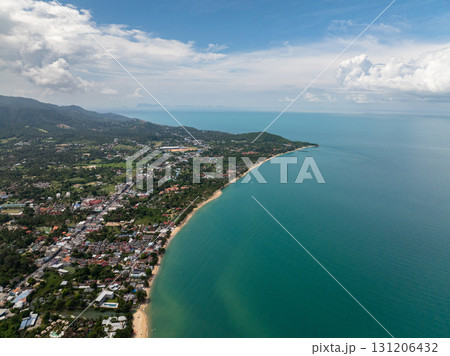 Lush tropical coastline with sandy beaches and calm turquoise waters extending to the horizon under a cloudy sky. Thailand, Koh Samui. 131206432
