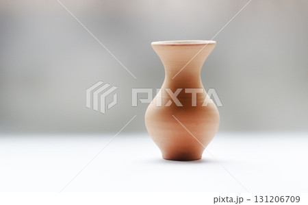A minimalistic ceramic pot with a unique shape on a gray-white background is ideal 131206709