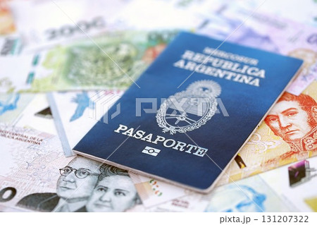 Argentine passport lies on Argentina pesos money bills close up. Travel and citizenship concept Argentine passport lies on Argentina pesos money bills close up. Travel and citizenship concept 131207322