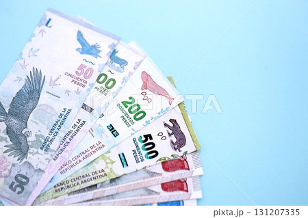 Argentine pesos money bills in big amount lies on teal color table close up. Finance and banking concept 131207335