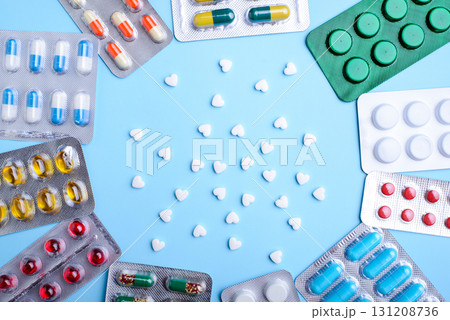 White pills in heart shape between packed pills in foil packing White pills in heart shape between packed pills in foil packing 131208736