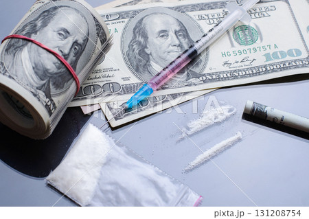 Drug Abuse. Drugs in plastic zip packaging, syringe with some liquid and dollar bills on black glass table Drug Abuse. Drugs in plastic zip packaging, syringe with some liquid and dollar bills on black glass table 131208754