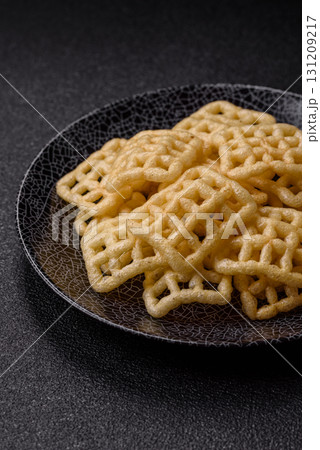 Lattice or wafer potato chips, crispy yellow snacks, takeaway food Lattice or wafer potato chips, crispy yellow snacks, takeaway food 131209217