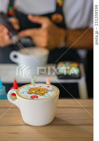 Cute latte art in form of cartoon cat with colorful elements served in white cup on wooden table. Concept of latte art, coffee creativity and fun cafe experience Cute latte art in form of cartoon cat with colorful elements served in white cup on wooden table. Concept of latte art, coffee creativity and fun cafe experience 131209599