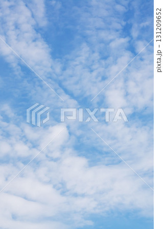 A vast blue sky adorned with fluffy white clouds drifting through it A vast blue sky adorned with fluffy white clouds drifting through it 131209652