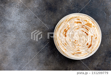 Indian paratha flatbreads on gray background. Indian food. Top view. Copy space. Indian paratha flatbreads on gray background. Indian food. Top view. Copy space. 131209779