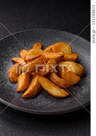 Grilled potato wedges with rosemary, cheese, salt and spices. Baked potato slices Grilled potato wedges with rosemary, cheese, salt and spices. Baked potato slices 131209815