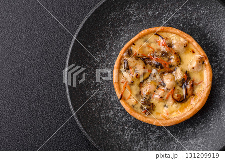Pie or quiche, a sour tart with chicken and mushrooms, spices and herbs. Round quiche with chicken 131209919