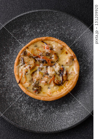 Pie or quiche, a sour tart with chicken and mushrooms, spices and herbs. Round quiche with chicken Pie or quiche, a sour tart with chicken and mushrooms, spices and herbs. Round quiche with chicken 131209920