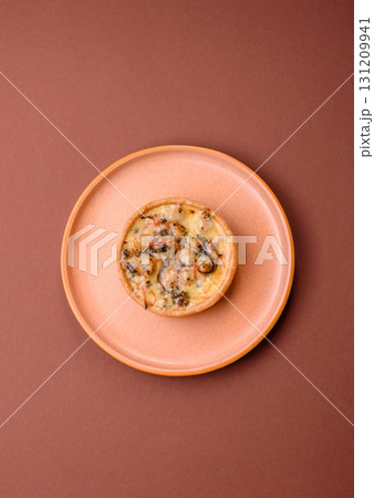 Pie or quiche, a sour tart with chicken and mushrooms, spices and herbs. Round quiche with chicken Pie or quiche, a sour tart with chicken and mushrooms, spices and herbs. Round quiche with chicken 131209941