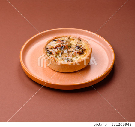 Pie or quiche, a sour tart with chicken and mushrooms, spices and herbs. Round quiche with chicken Pie or quiche, a sour tart with chicken and mushrooms, spices and herbs. Round quiche with chicken 131209942