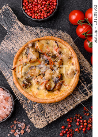 Pie or quiche, a sour tart with chicken and mushrooms, spices and herbs. Round quiche with chicken Pie or quiche, a sour tart with chicken and mushrooms, spices and herbs. Round quiche with chicken 131209952