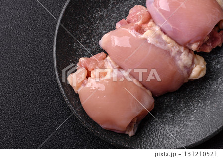 Raw chicken thigh fillet without skin and bone with salt and spices. Raw chicken fillet for cooking 131210521