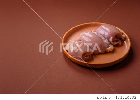 Raw chicken thigh fillet without skin and bone with salt and spices. Raw chicken fillet for cooking 131210532