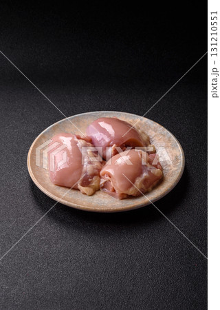 Raw chicken thigh fillet without skin and bone with salt and spices. Raw chicken fillet for cooking Raw chicken thigh fillet without skin and bone with salt and spices. Raw chicken fillet for cooking 131210551