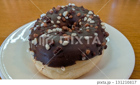 A Delicious and Tempting Chocolate Donut with Toppings Perfectly Placed on a Plate A Delicious and Tempting Chocolate Donut with Toppings Perfectly Placed on a Plate 131210817