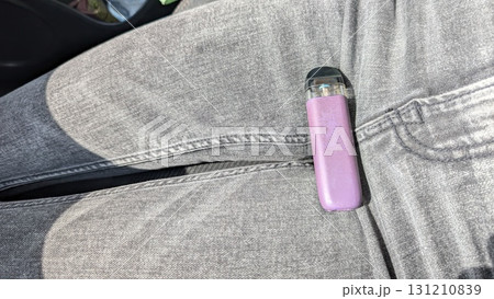 A Casual Vaping Moment A Trendy Vape Pen Resting Stylishly Upon a Pair of Jeans During Leisure Time A Casual Vaping Moment A Trendy Vape Pen Resting Stylishly Upon a Pair of Jeans During Leisure Time 131210839
