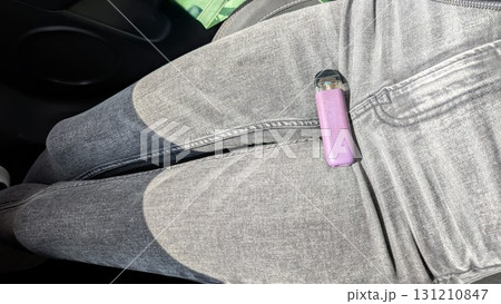 Discover the latest fashionable grey jeans perfectly paired with a trendy vape device 131210847