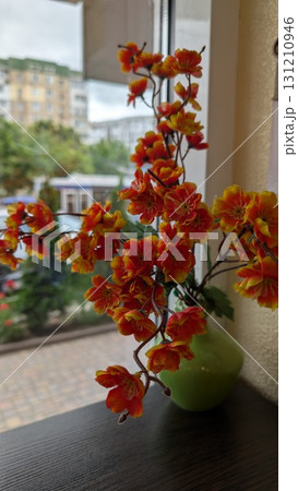 A beautiful arrangement of vibrant faux flowers elegantly displayed in a decorative vase A beautiful arrangement of vibrant faux flowers elegantly displayed in a decorative vase 131210946
