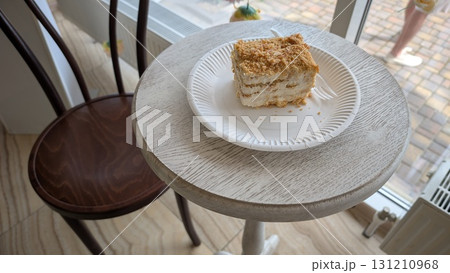 A Delicious and Tempting Cake Slice Displayed on a Beautiful Wooden Table Surface 131210968