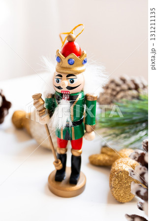 Festive wooden nutcracker ornament with crown and scepter on holiday display Festive wooden nutcracker ornament with crown and scepter on holiday display 131211135